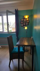 comedor con mesa de madera y silla en Chambre d'hôtes Le Cyprès Bleu, en Roussillon en Isère