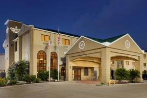 a building with a flag in front of it at Country Inn & Suites by Radisson, Houston Northwest, TX in Houston