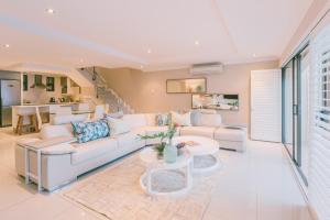 un soggiorno con divano bianco e tavolo di Bronze Beach Villa a Durban