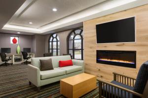 sala de estar con sofá y chimenea en Country Inn & Suites by Radisson, Houston Northwest, TX, en Houston