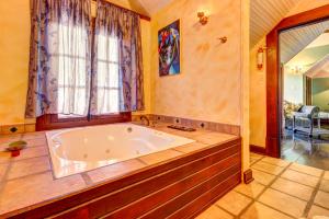 a large bath tub in a room with a window at Toucan Suite @ Mahogany Hall in San Ignacio