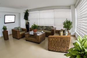 a living room with wicker furniture and a table at Hotel Altamar Cartagena in Cartagena de Indias