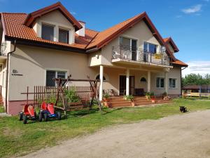 a house with two toy cars in front of it at Słoneczna Przystań in Kruklanki