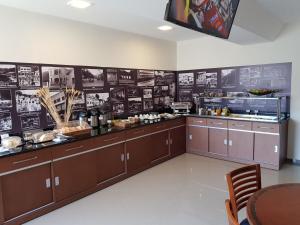 a kitchen with brown cabinets and posters on the wall at Paracambi Top Hotel in Paracambi