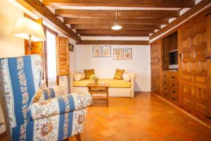 uma sala de estar com um sofá e uma mesa em El Bulín de Pedraza - Casa del Serrador em Pedraza-Segovia