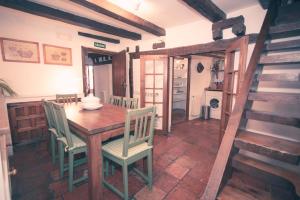 una cucina e una sala da pranzo con tavolo e sedie in legno di El Bulín de Pedraza - Casa del Serrador a Pedraza-Segovia