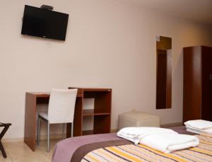 a bedroom with a bed and a desk and a television at Hotel Los Naranjos in General Deheza +75 photos