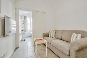 a living room with a couch and a table at Le Petit Pavillon de Versailles in Versailles