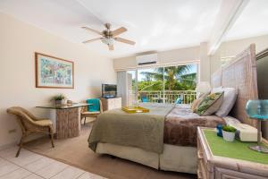 a bedroom with a bed and a desk and a window at Waikiki Shore 305 (beachfront/balcony) in Honolulu