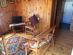 a room with a chair and a tv in a room at Lomita Quebrada in Pichilemu