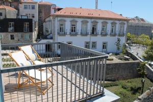 波多的住宿－Amazing Penthouse Apartment in historic Porto，阳台配有两把椅子,大楼