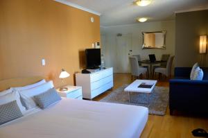 1 dormitorio con 1 cama y sala de estar en Frisco Apartments, en Brisbane