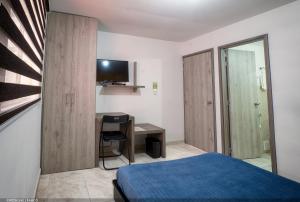 a bedroom with a bed and a desk with a television at Casa Borbon in Salento