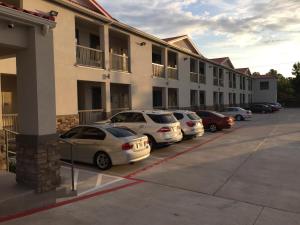 a row of cars parked in front of a building at Scottish Inn and Suites in Katy