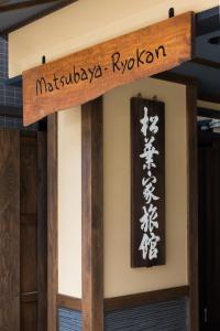 a wooden sign hanging from the side of a wall at Matsubaya Ryokan in Kyoto