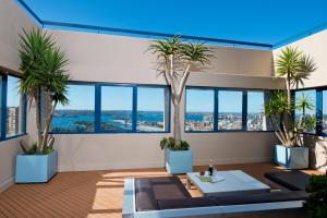 雪梨的住宿－柏偉詩城市中心酒店，一间拥有棕榈树和蓝色天花板的客房
