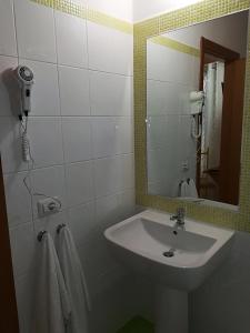 a bathroom with a sink and a mirror and towels at Residenza Skanderbeg in Montecilfone