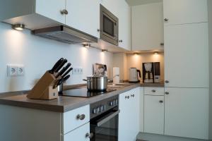 a kitchen with white cabinets and a stove top oven at Südkap D-08 in Pelzerhaken