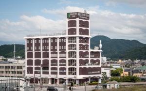 a large building with a clock tower on top of it at Mizuho Inn Iwami Masuda in Masuda