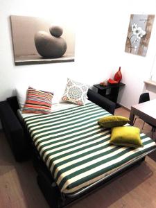 a bed with a black and white striped sheets and pillows at L'Angoletto in Ciampino