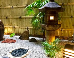 a japanese garden with a lantern and a bird bath at Matsubaya Ryokan in Kyoto
