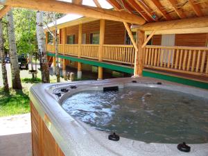 a hot tub in the backyard of a log cabin at Jared's Wild Rose Ranch Resort in Island Park