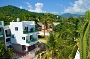 an aerial view of a white building with palm trees at Casa de Mony in Santa Marta