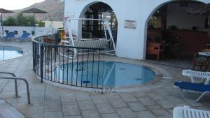 a swimming pool with a fence around it at Apostolis Hotel Apartments in Pefki
