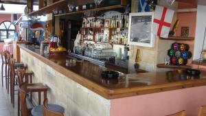 a bar in a restaurant with a wooden counter top at Apostolis Hotel Apartments in Pefki