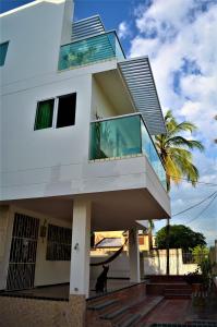 Biały dom z balkonem i palmą w obiekcie Casa de Mony w mieście Santa Marta