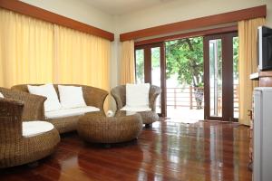 een woonkamer met rieten stoelen en een televisie bij Phangka Paradise Resort in Taling Ngam Beach
