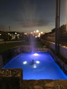 una persona en una piscina con una fuente por la noche en La Pina, en Rezzato