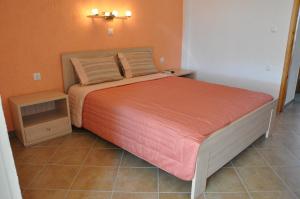 een slaapkamer met een bed met een oranje muur bij Villa Annilena in Eratini