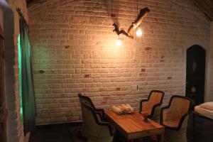 - une table et des chaises dans une pièce dotée d'un mur en briques dans l'établissement Shannu's Ranch Inn, à Pushkar