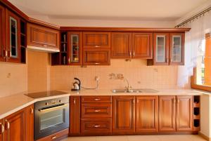 uma cozinha com armários de madeira e um lavatório em Apartament Dana em Poronin
