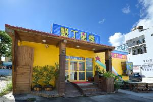 a small yellow building with a sign on top at Star Inn 888 in Kenting