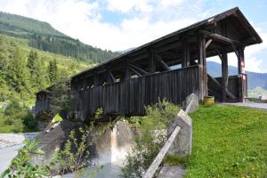 un puente de madera sobre un río en las montañas en Camping Sur En en Sent