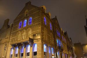 a building with blue and purple lights on it at Carmelite Hotel; BW Signature Collection in Aberdeen