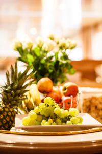 ein Teller mit Trauben und anderen Früchten auf einem Tisch in der Unterkunft Hotel Salzburg in Salzburg