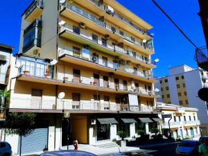 a tall yellow building with balconies on a street at Boite d'Esprit b&b de luxe in Rossano Stazione