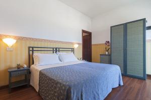 sypialnia z dużym łóżkiem i niebieskim kocem w obiekcie Hotel Regina in spiaggia w Rimini