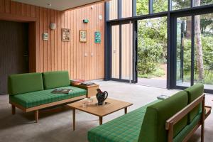 a living room with two green chairs and a table at Eden Lodge Paris in Paris