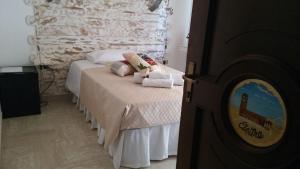 a bedroom with a bed and a stone wall at Bed and Breakfast Elettra in Marconia