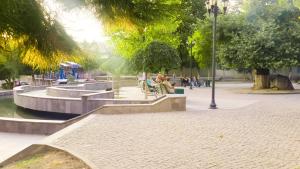 un parco con persone sedute su panchine e una fontana di Hostel Near The Square a Tbilisi City