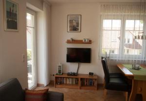 uma sala de estar com uma televisão e uma mesa e cadeiras em Fewo Zinnowitz Ostseequartett em Zinnowitz