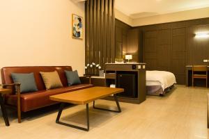 a hotel room with a couch and a bed at V-Hotel in Taitung City +39 photos