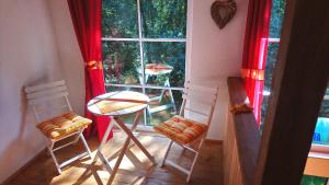 two chairs and a table in a room with a window at Finnhütte Rudolf in Garitz