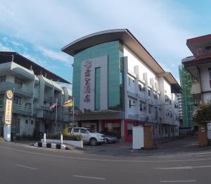 a building with a car parked in a parking lot at Raja Inn in Miri