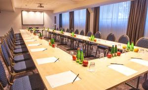 a large conference room with long tables and chairs at Centennial Nexus Hotel Tallinn in Tallinn