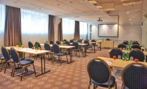 a conference room with tables and chairs and a projection screen at Centennial Nexus Hotel Tallinn in Tallinn